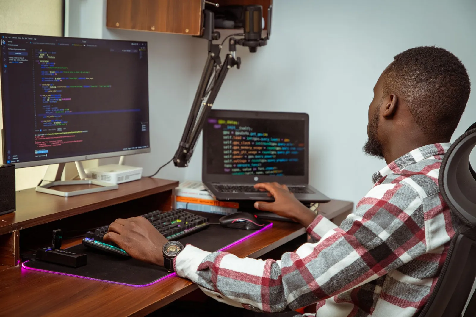 A developer writing code across two screens.